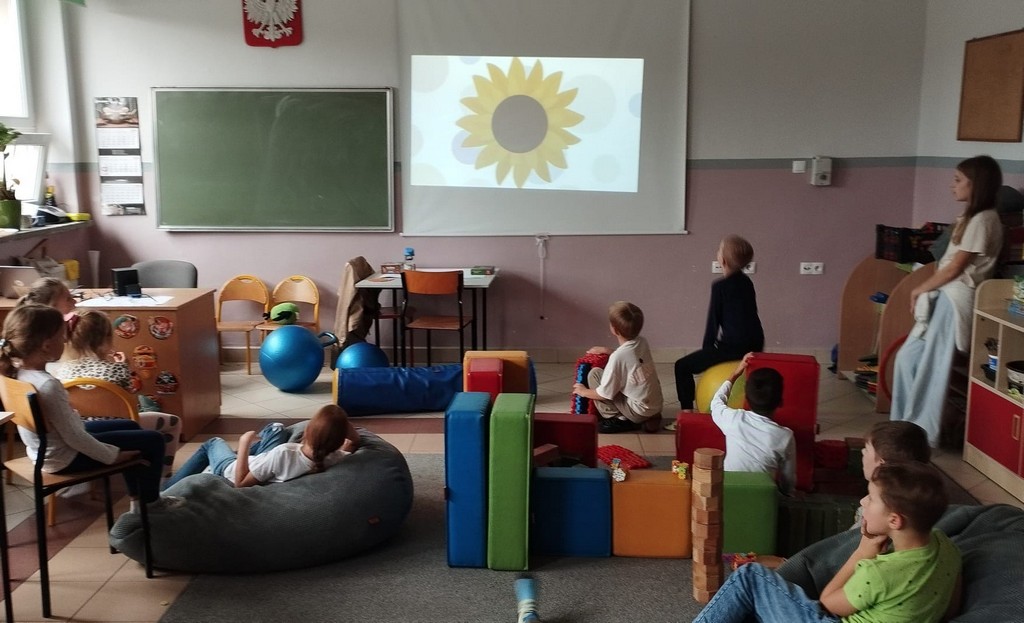 Grupa dzieci ogląda film edukacyjny na temat Dnia Kropki