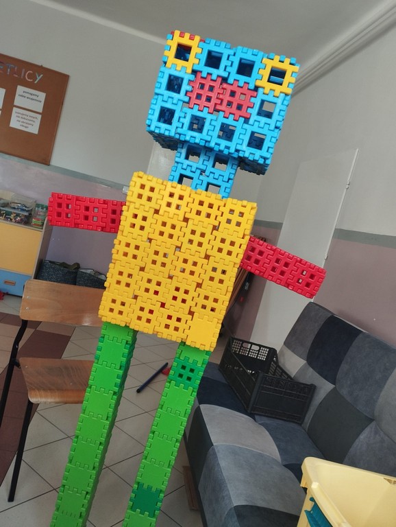 Zdjęcie przedstawia ogromnego robota zbudowanego przez dzieci z klocków waflowych
